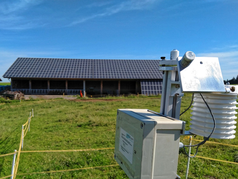 Messstation vor einer grünen Wiese unter blauem Himmel -