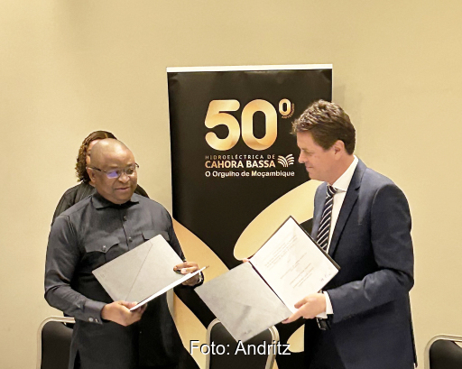 Zwei Männer mit Vertragsunterlagen in der Hand im Gespräch.