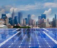 Blick über Photovoltaik-Module auf die Skyline von New York, USA