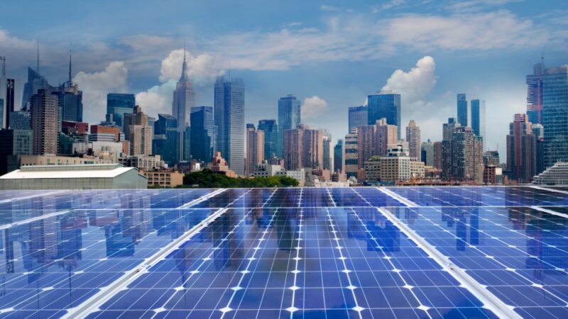 Blick über Photovoltaik-Module auf die Skyline von New York, USA