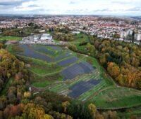 Luftbild einer PV-Freiflächenanlage am Rande einer Kleinstadt.