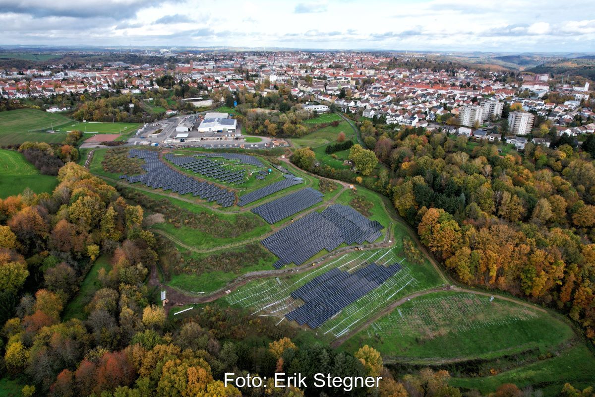 Luftbild einer PV-Freiflächenanlage am Rande einer Kleinstadt.