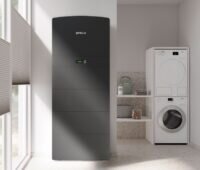 Der Batteriespeicher Storac LFP All-in-One neben einer Waschmaschine, Prolux stellt neues HEMS auf der Intersolar /ESS Eruope vor.