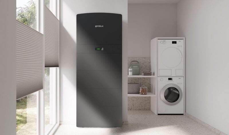 Der Batteriespeicher Storac LFP All-in-One neben einer Waschmaschine, Prolux stellt neues HEMS auf der Intersolar /ESS Eruope vor.