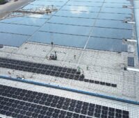 Revamping (Modernisierung) einer Photovoltaik-Dachanlage auf einer Logistikhalle in Philippsburg mit neu aufgeständerten Solarmodulen auf dem Hallendach mit Blick aus der Vogelperspektive.