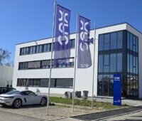Das Verwaltungsgebäude von SAX Power vor einem blauen Himmel, betrachtet vom Parkplatz der Stromspeicher-Herstellerin.