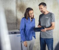 Verkaufsgespräch zwischen Installateur und Kundin von Energiespeicher