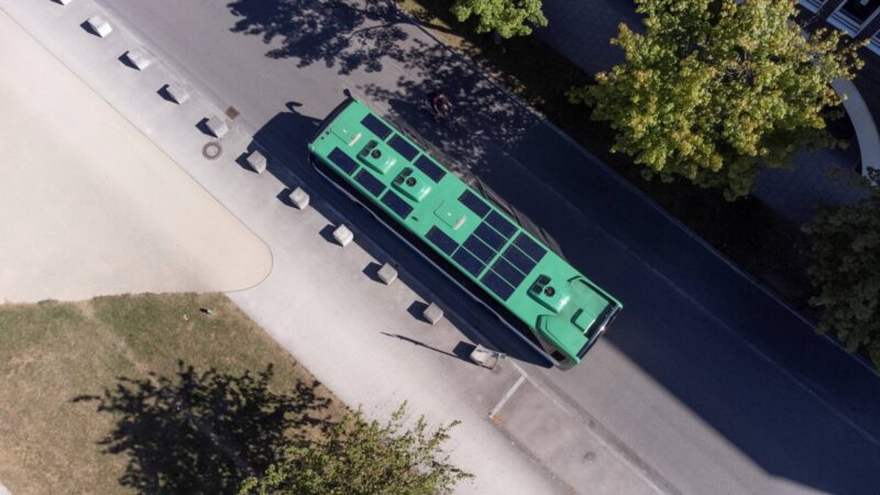 Luftbild zeigt einen Bus von oben mit Photovoltaikmodulen auf dem Dach.