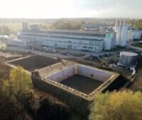 Im Hintergrund das Gebäude von Solmax, im Vordergrund die Erdbecken-Wärmespeicher
