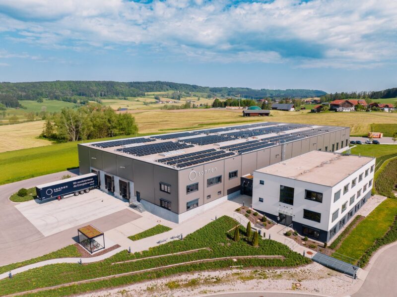 Eine Fabrik mit Solarmodulen auf dem Dach im malerischen Allgäu.