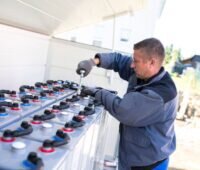 Ein Arbeiter prüft eine Batterieanlage.