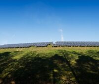 Ein Solarpark auf einem Hügel in der Ferne.