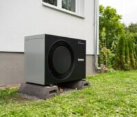 Wärmepumpe vor einem Haus.