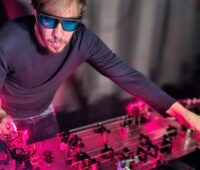 Ein Forscher mit Schutzbrille arbeitet bei rotem Licht an einer Apparatur.