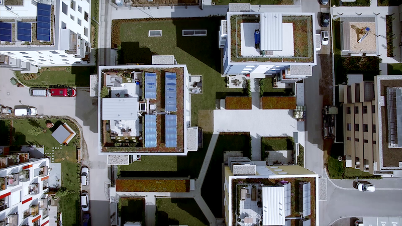 Luftaufnahme von Gebäuden mit Solarkollektoren auf den Dächern.