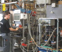 Mitarbeiter in einer Werkhalle prüft elektrisches Equipment