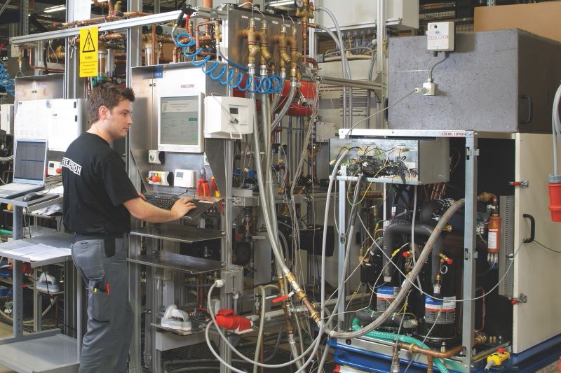 Mitarbeiter in einer Werkhalle prüft elektrisches Equipment