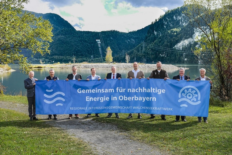 Männer mit blauem Banner vor Walchensee und Bergen, Wasserkraftwerk Walchensee