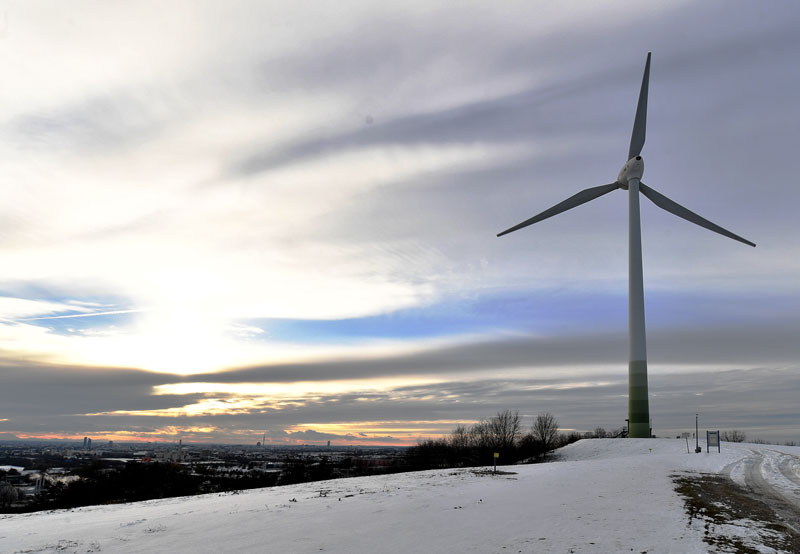 Windkraftwerk auf der ehemaligen Deponie in München-Fröttmaning mit Schnee und Sonnenuntergang