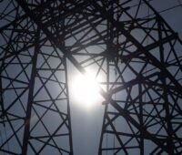 Zu sehen ist ein Strommast im Sonnenschein als Symbol für das Monopol im Netzbetrieb, gegen das sich die Initiative #wirspielennichtmit wehren will.